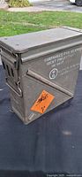 Front and left side of PA-125 ammo can showing stencil text and hazard label