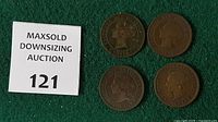 Obverse view of four large cents beside lot marker