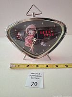 Front view of triangular Betty Boop alarm clock with measuring tape for scale
