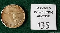 Reverse view of 1967 Canadian silver dollar next to lot tag
