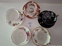Five teacup and saucer sets displayed overhead