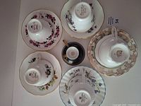 Top view showing all five cup-and-saucer sets plus extra cup