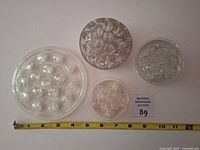 Top view of all four glass flower frogs with measuring tape showing approx 6 inch length