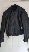 Front view of black leather motorcycle jacket on hanger