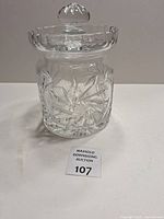 Front view of cut glass jar with lid and lot tag