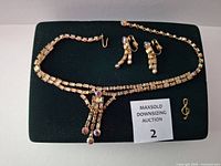Full set on display pad showing necklace, three earrings, treble clef pin