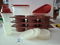 Overall lot view showing stacked brown relish trays, clear lids, tall cereal container, small storage containers