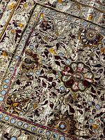 Full view of embroidered fabric wall hanging showing floral motifs and mirror accents