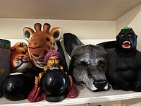 Shelf view of masks, fortune-teller figure, Magic 8 Balls and gorilla figurine