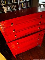 Full view of red chest showing drawers and legs