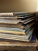 Tall stack of vinyl LPs showing worn edges