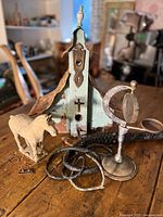 Group shot of entire lot: birdhouse, horse figurine, whips, metal stand