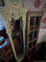 Ornate mirror alongside window-pane mirror showing size and frames