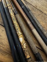 Close view of cue butts showing finishes and carvings