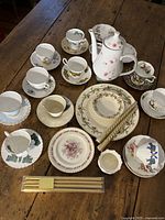 Overhead view of entire lot showing teapot, teacups with saucers, plates, loose candles and boxed candles