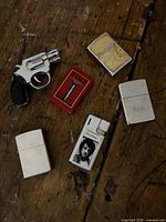 Group shot of six Zippo lighters on wood surface