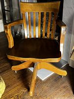 Front view of wooden swivel chair showing slat back and seat