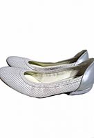 Lateral view of pair showing white perforated leather uppers and silver heel counters