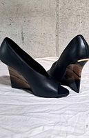 side view of both shoes showing lucite wedge heels and leather uppers