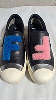 Top view showing both sneakers with blue and pink shearling F letters