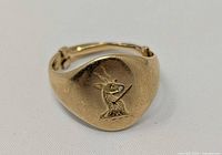 Top view showing engraved family crest on oval face