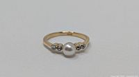 Front view showing cultured pearl and four diamonds on yellow/white gold band