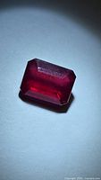 Front view of emerald-cut ruby under spotlight