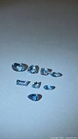 All eight faceted aquamarines laid out on neutral background showing mixed cuts
