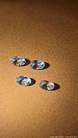 Four oval aquamarines on textured surface