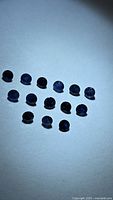 Group of round deep blue sapphires under spotlight