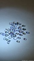 Group of loose oval-cut tanzanites on neutral background under spotlight