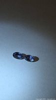 Pair of oval tanzanites under direct light