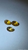 Three oval yellow sapphires on neutral background