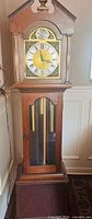 Full view of wooden grandfather clock showing overall design and size