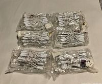 Six sealed plastic packages of white wire LED string lights