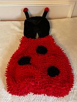 Front view of plush ladybug bubble tunic with hat attached showing overall design