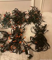 Tangled bundles of green-wire mini LED light strands with mixed colored bulbs