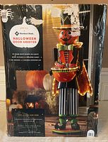 Front of retail box showing full image of 4ft pre-lit pumpkin greeter