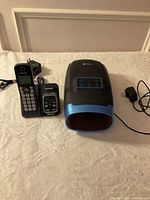 All items including Panasonic phone handset and base, Lifepro hand massager, power adapters and cords