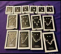 All 14 boxed crystal necklace and earring sets laid out
