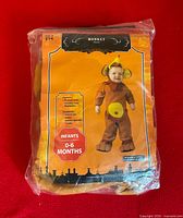 Front view of packaged infant monkey costume