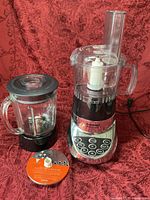 Motor base with plastic processor bowl assembled, glass blender jar and slicing/shredding disc displayed