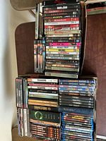 Two stacks of DVDs and Blu-rays on table, showing spine titles and quantity