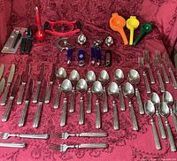 Full layout of flatware and utensils on red cloth