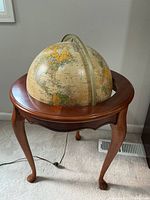Front view showing wooden stand and upper half of globe