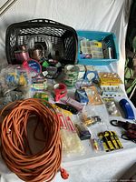 Overview showing extension cord, tape rolls, wire spools, baskets and various packaged items