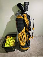 Full lot view with bag, clubs, swing trainer, crate of balls