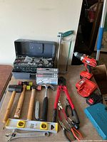 Overview of all tools on table including drill, organiser box, hacksaw