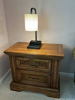 Front view of nightstand with lamp on top