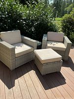 Two grey wicker armchairs with ottoman on deck